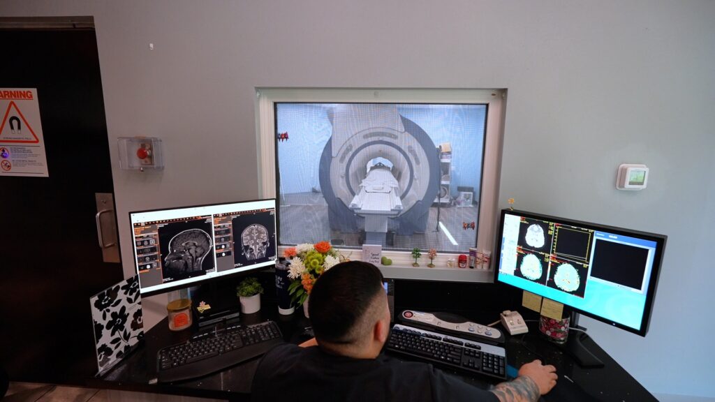 MRI technologist reviewing scans in the control room at Riverside Elite Imaging in Riverside, CA