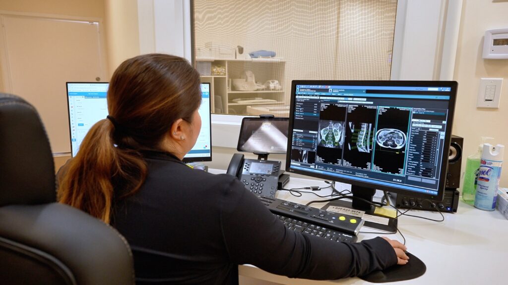MRI technologist reviewing scans in the control room at San Bernardino Open MRI in San Bernardino, CA