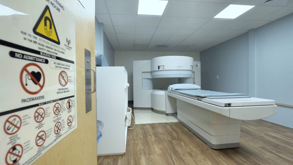 Open MRI scanner suite with patient safety signage at Westminster Open MRI in Westminster, CA